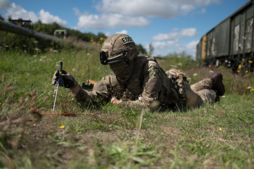 EOD operator positions a shaped charge above UXO