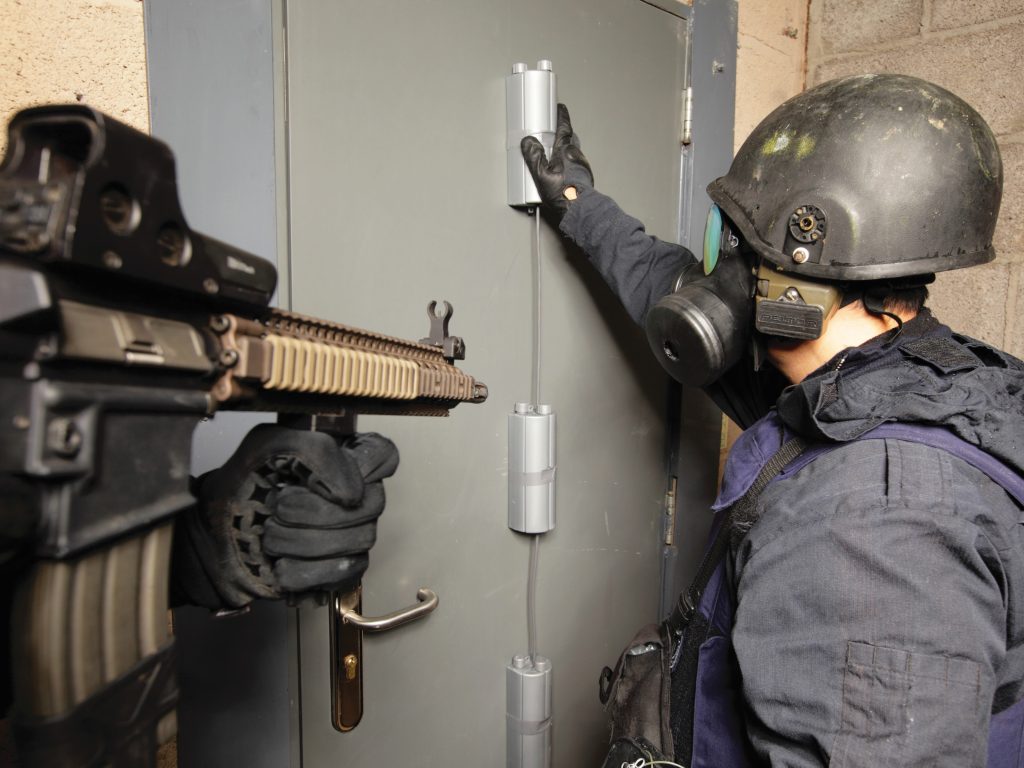 An operator positioning Breachers Boot charges against a door