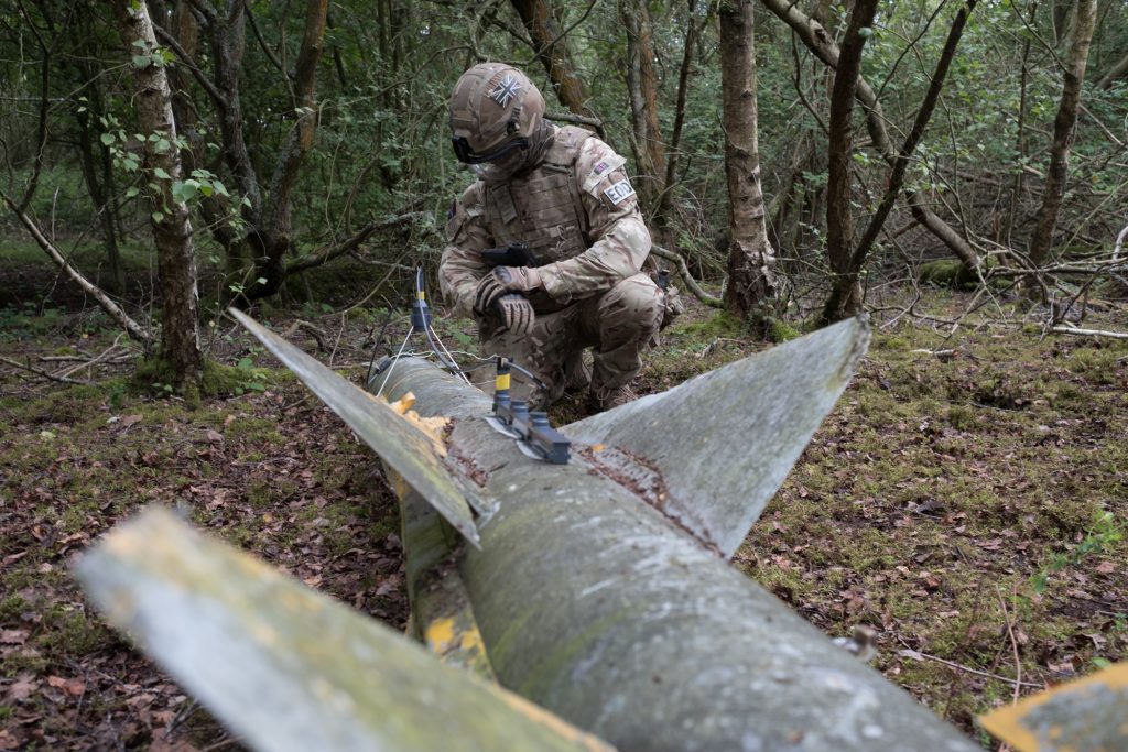 An EOD operator positioning Alford Vulcan shaped charge and Dioplex cutting charge against UXO