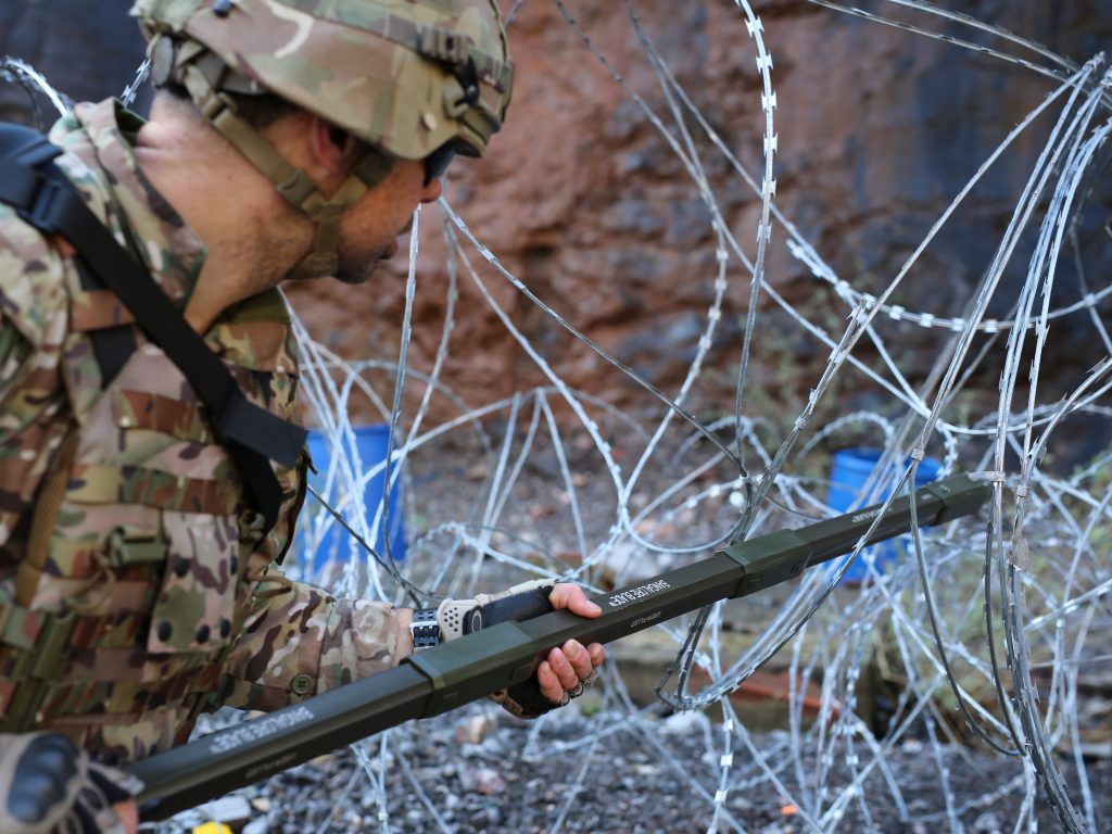 An operator clearing razor wire entanglement with Bangalore Blade