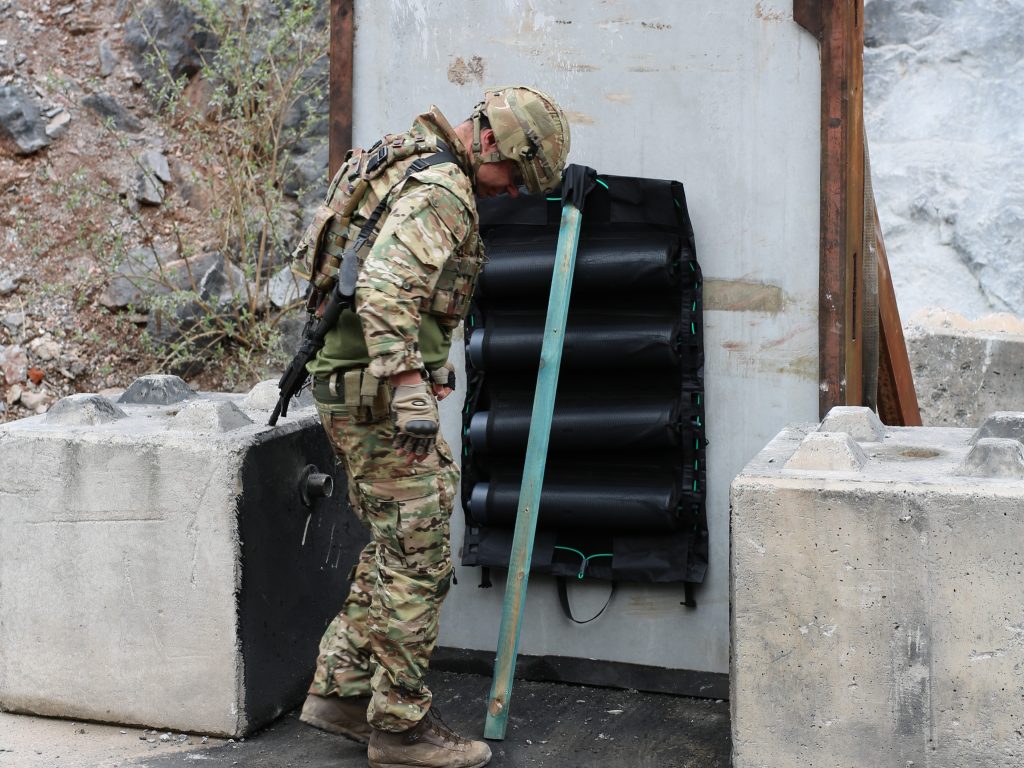 An operator positioning Gatecrasher Modular to breach a concrete wall