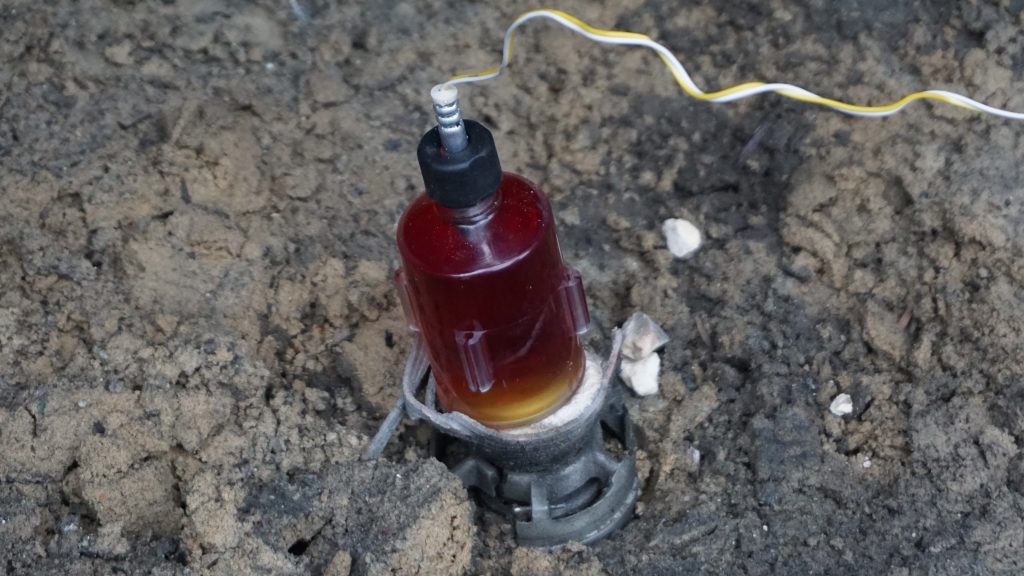 Alford's J-Etna low order explosive EOD tool positioned against UXO