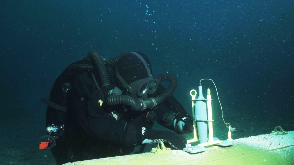 Diver positions Pluton shaped charge against underwater UXO for low order