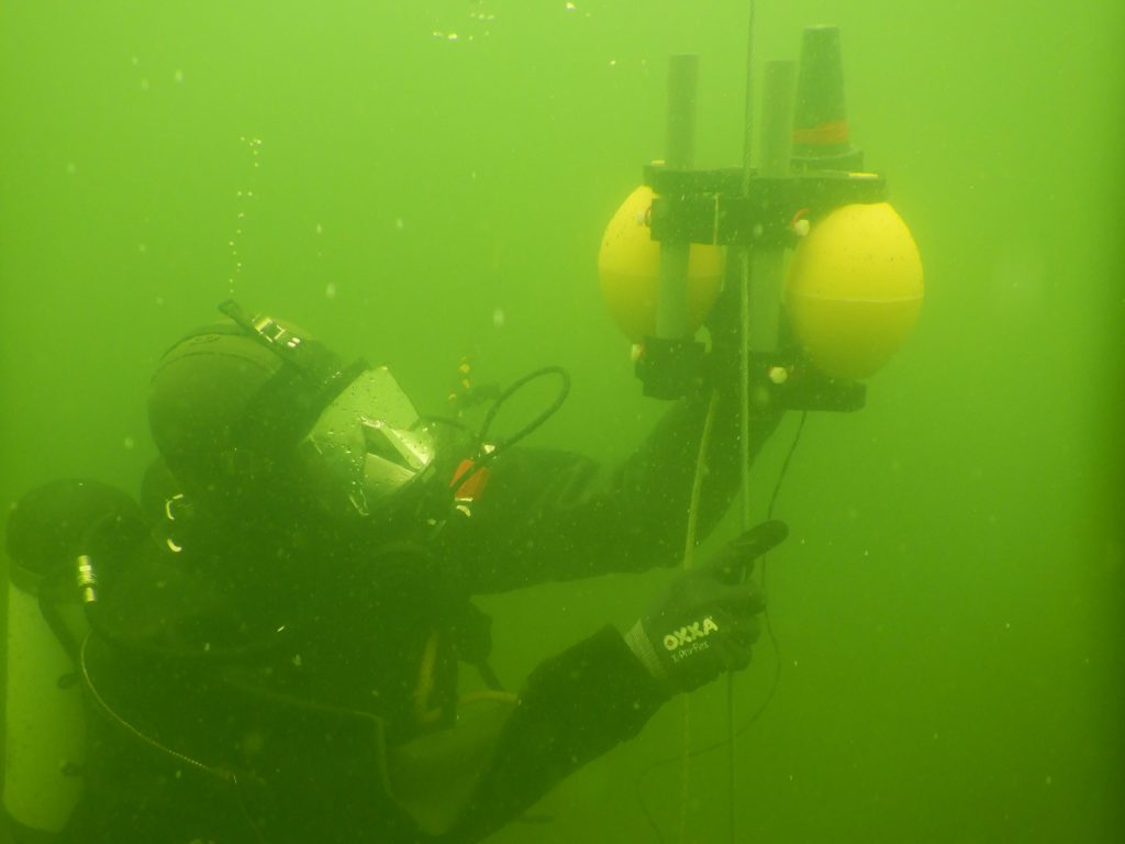 A diver uses the Buoyant Mine Attachment to attack a floating mine with a shaped charge