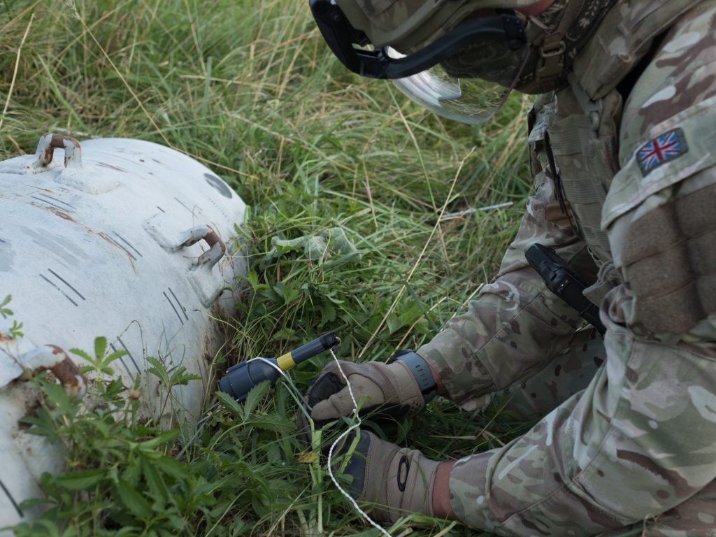 An EOD operator positions a Vulcan shaped charge against UXO