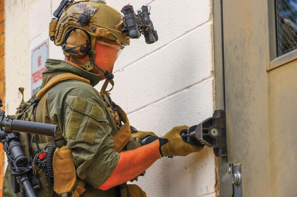 An operator using Holmatro door ram DR200ST to force open a door